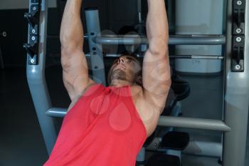 Man Lies On A Bench And Does Dumbbell Presses
