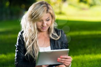 Young Woman using a digital tablet in the park