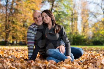 Couple Sitting Together In The Woods During Autumn