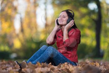 Young Woman Listening To Music In Nature