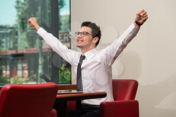 Successful Business Man With Arms Up At The Office