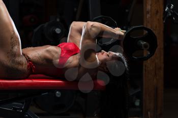 Young Woman In Underwear Doing Heavy Weight Exercise For Triceps With Barbell