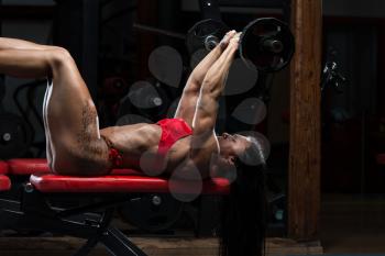 Young Woman In Underwear Doing Heavy Weight Exercise For Triceps With Barbell
