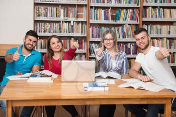 Portrait Of A Group Of Students Showing Thumbs Up In College Library - Shallow Depth Of Field