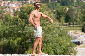 Portrait Of A Physically Fit Man Showing His Well Trained Body Outdoors In Summer Time