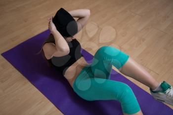 Young Woman Exercising Her Abs On Mat In The Fitness Studio