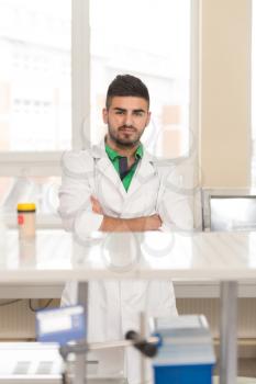Portrait Of A Arabic Student In A Chemistry Lab Smiling And Looking In The Camera With Hands Folded