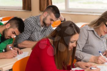 Young Group Of Attractive Teenage Students In A College Classroom Sitting At A Table - Learning Lessons