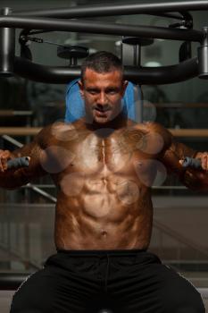 Adult Bodybuilder Doing Heavy Weight Exercise For Chest On Machine