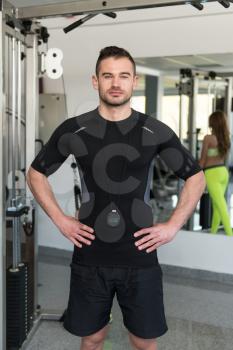 Personal Trainer Wearing Sportswear And Standing In A Gym Or Fitness Club Center
