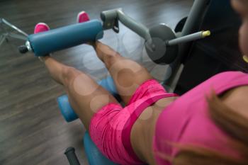 Leg Exercises Close Up -  Young Woman Doing Leg With Machine In Gym