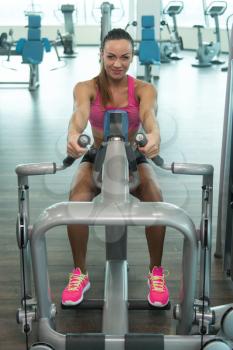Young Woman Exercising Back On Machine In The Gym And Flexing Muscles - Muscular Athletic Bodybuilder Fitness Model