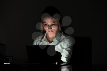 Young Attractive Woman Sitting At Desk And Working With A Laptop Late At Night - Successful Businesswoman At Work