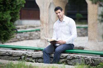 Humble Muslim Man Is Reading The Koran Outdoors