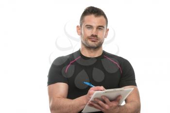 Handsome Personal Trainer With A Clipboard Isolated On A White Background