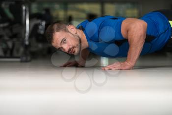 Personal Trainer Doing Pushups On Floor In Gym As Part Of Bodybuilding Training