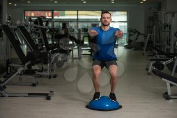 Personal Trainer Doing A Exercise With Bosu Balance Ball As Part Of Bodybuilding Training