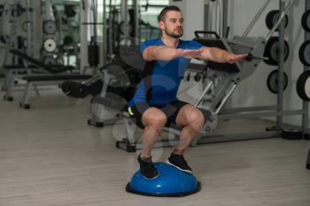 Personal Trainer Doing A Exercise With Bosu Balance Ball As Part Of Bodybuilding Training