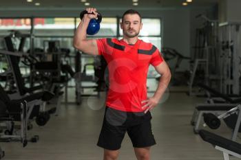 Personal Trainer Working Out With Kettle Bell In A Gym - Attractive Fitness Instructor Doing Heavy Weight Exercise With Kettle-bell