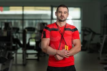 Portrait Of A Physically Fit Man Personal Trainer Posing With Jumping Rope In Modern Fitness Center Gym