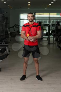Portrait Of A Physically Fit Man Personal Trainer Posing With Jumping Rope In Modern Fitness Center Gym
