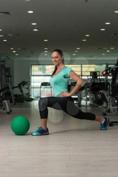 Attractive Woman Doing Stretching With Medicine Ball As Part Of Bodybuilding Training