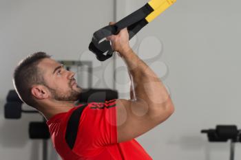 Personal Trainer Does Crossfit With Trx Fitness Straps In The Gym's Studio