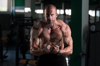 Bald Man Standing Strong In The Gym And Flexing Muscles - Muscular Athletic Bodybuilder Fitness Model Posing After Exercises