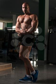 Bald Man Standing Strong In The Gym And Flexing Muscles - Muscular Athletic Bodybuilder Fitness Model Posing After Exercises