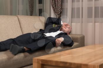 Handsome Young Man in Suit and Tie Sleeping or Resting in Sofa