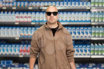 Handsome Bald Man Shopping With Sunglasses For Fruits And Vegetables In Produce Department Of A Grocery Store - Supermarket - Shallow Deep Of Field