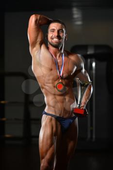 Bodybuilder Competitor Showing His Winning Medal - Male Fitness Competitor Showing His Winning Medal