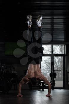 Young Man Athlete Doing Extreme Pushups Handstand As Part Of Bodybuilding Training