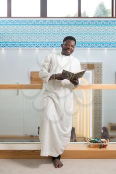 Portrait Of A African Muslim Man Making Traditional Prayer To God While Wearing A Traditional Cap Dishdasha