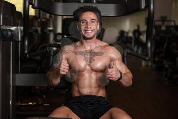 Muscular Man Showing Thumbs Up While Standing Strong In A Gym And Flexing Muscles - Muscular Athletic Bodybuilder Fitness Model Posing After Exercises