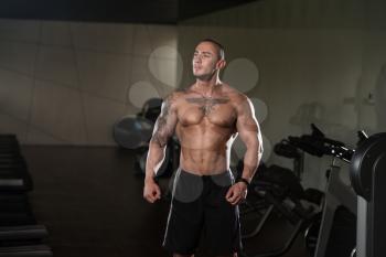 Healthy Young Tattoo Man Standing Strong In The Gym And Flexing Muscles - Muscular Athletic Bodybuilder Fitness Model Posing After Exercises