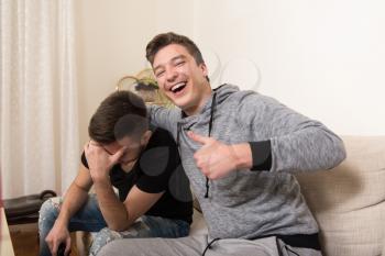 Two Men Competitive Friends Playing Video Games and Excited Happy Cheerful at Home