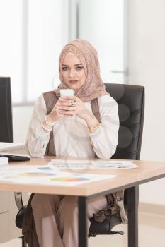 Young Cheerful Muslim Business Woman Working With Computer At Desk In The Modern Office And Talking On Phone