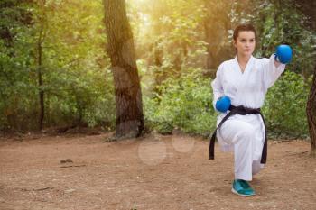 Young Woman Dressed In Traditional Kimono Practicing Her Karate Moves in Wooded Forest Area - Black Belt