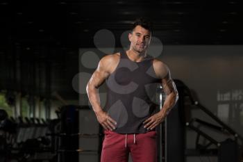 Portrait Of A Young Physically Fit Man In Black Undershirt Showing His Well Trained Body - Muscular Athletic Bodybuilder Fitness Model Posing After Exercises