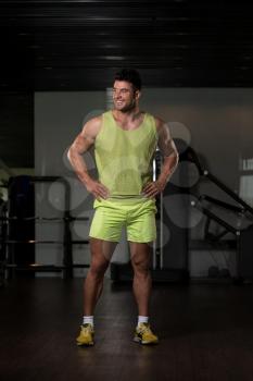Handsome Young Man Standing Strong in Green T-shirt and Flexing Muscles - Muscular Athletic Bodybuilder Fitness Model Posing After Exercises