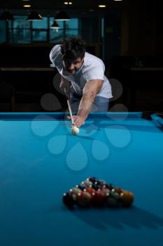 Young Man Playing Billiards Lined Up To Shoot Easy Winning Shot
