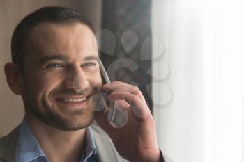 Happy Young Business Man Work In Modern Living Room and Talking On the Phone