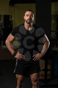 Portrait Of A Young Physically Fit Man Showing His Well Trained Body In Black Shirt - Muscular Athletic Bodybuilder Fitness Model Posing After Exercises
