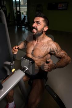 Handsome Fitness Man Doing Heavy Weight Exercise For Back On Machine