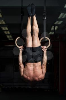 Adult Man Exercising While Holding Large Gymnastic Rings At The Gym