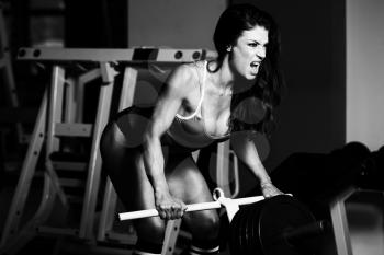 Muscular Fitness Woman Athlete Doing Heavy Weight Exercise For Back With Barbell In The Gym