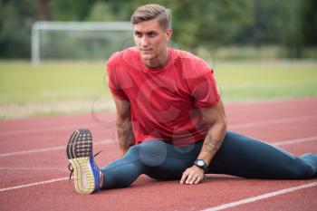 Portrait of Fit and Sporty Young Man Doing Stretching in the Park