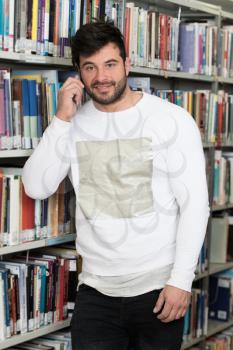 Young Bearded Student Talking Phone While Preparing for Exams in Univercity Library