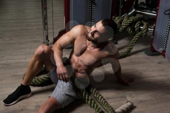 Battling Ropes Young Man At Gym Resting After Workout Exercise